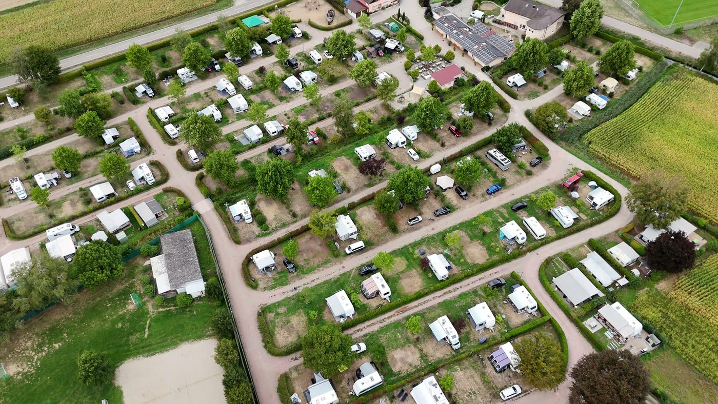 Voll belegter Campingplatz zwischen Feldern, von oben